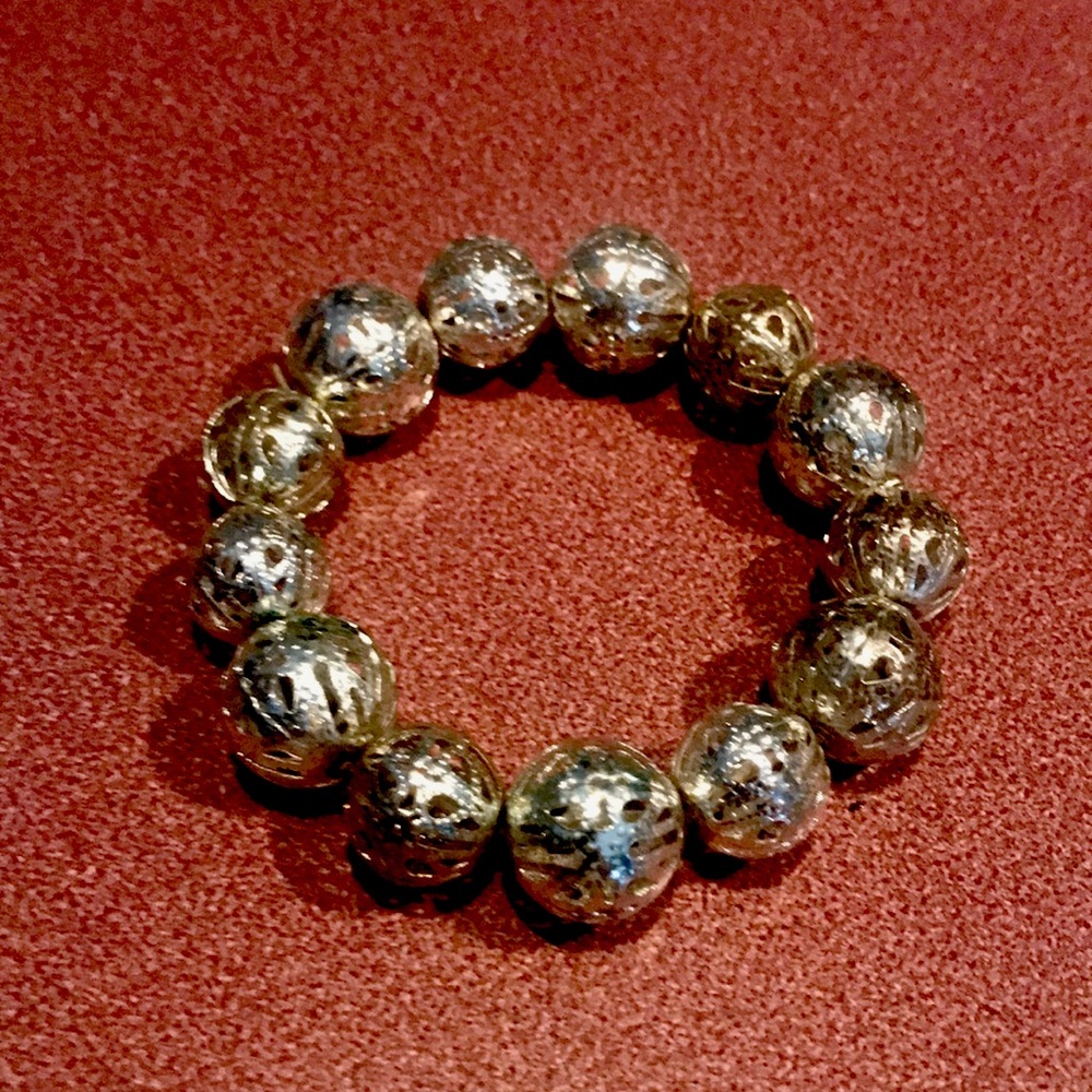 Very light weight stretch bracelet beads are silver with cut out designs on them
